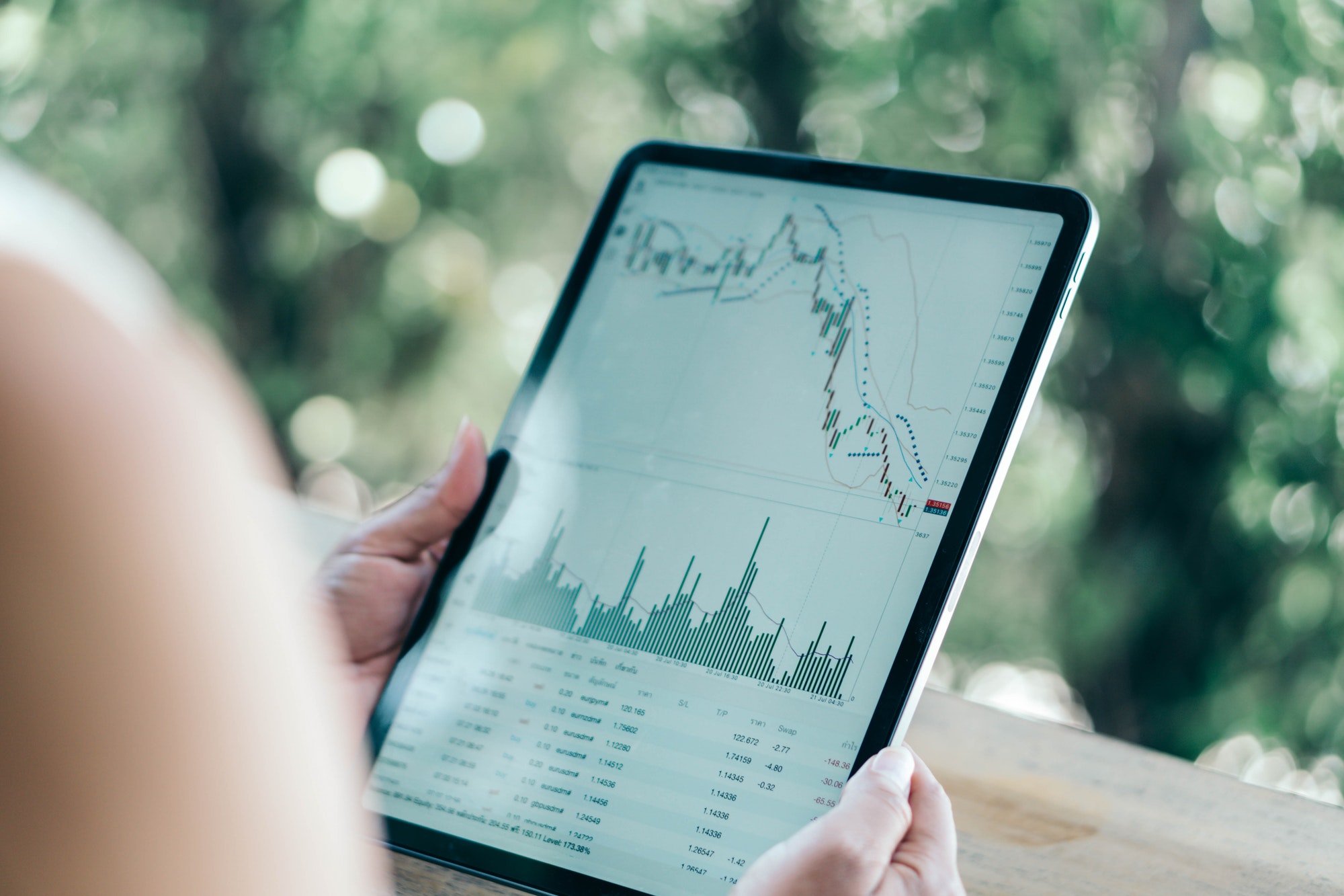 business-woman-hand-holding-digital-tablet-computer-with-graph-of-binary-option-for-trading-platform